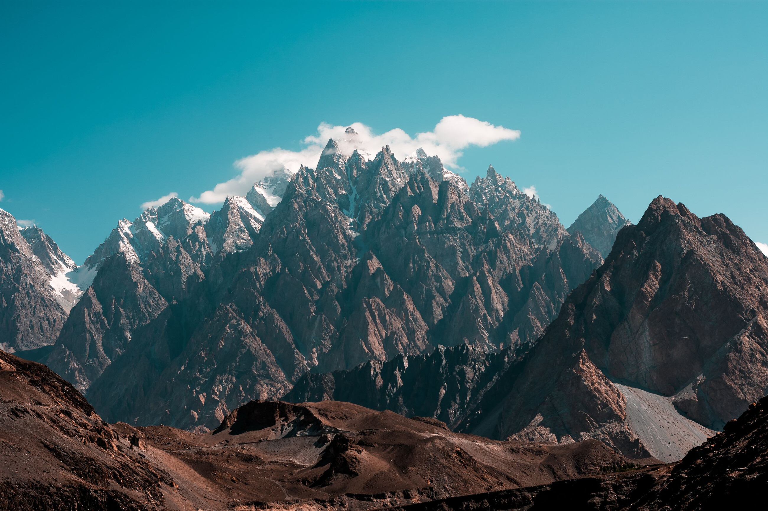 Bare mountain peaks under thin cloud.
