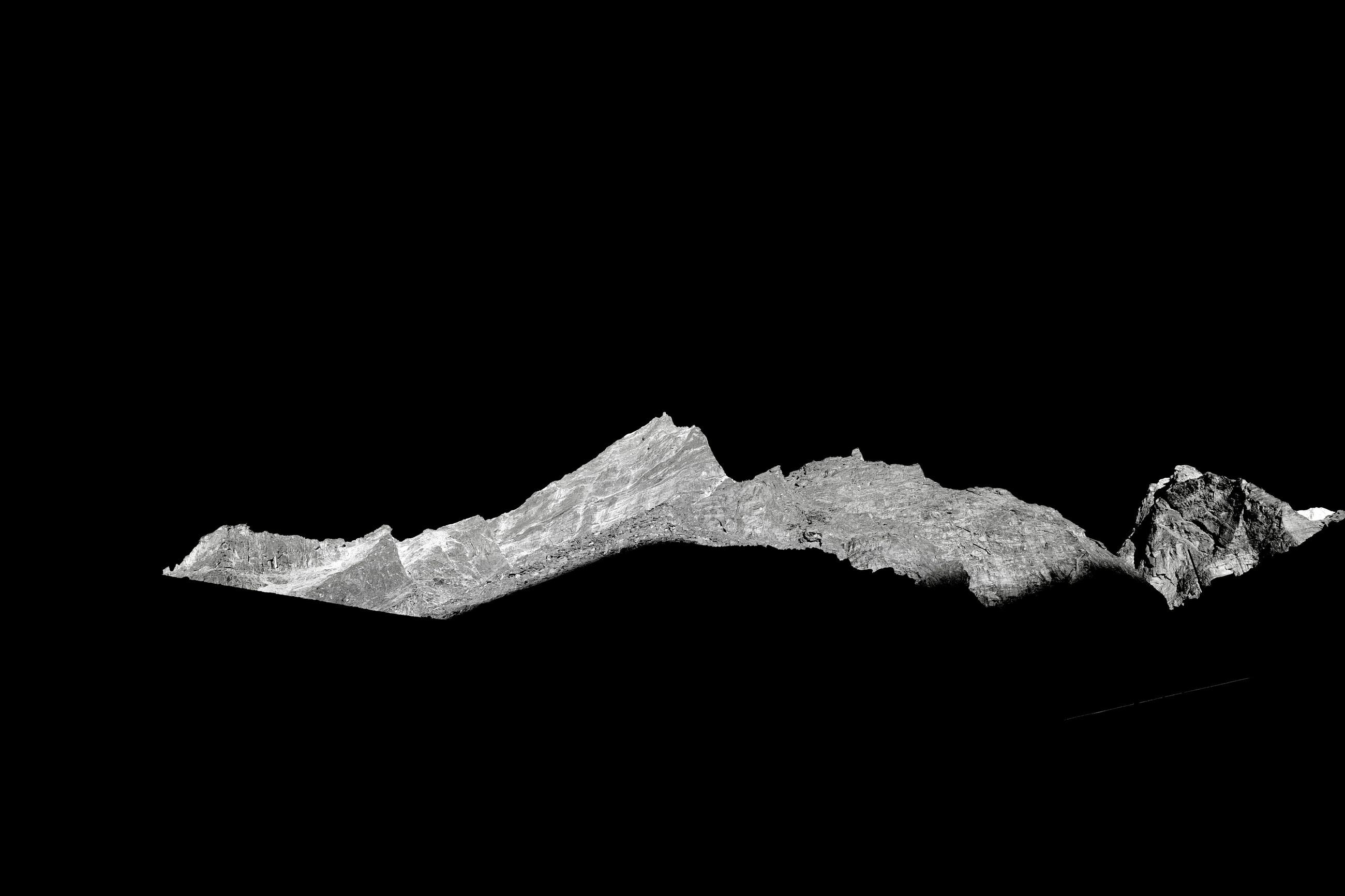 A lit ridge standing out of pure black.